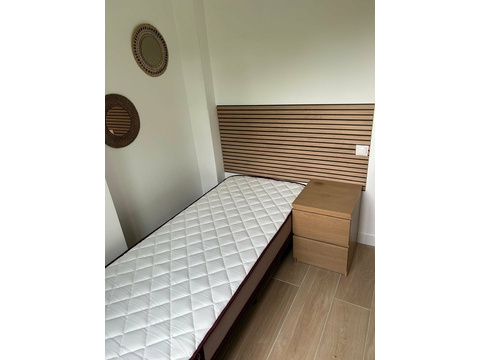 Komfortables Schlafzimmer mit durchdachtem Stauraum und modernem Kopfteilelement