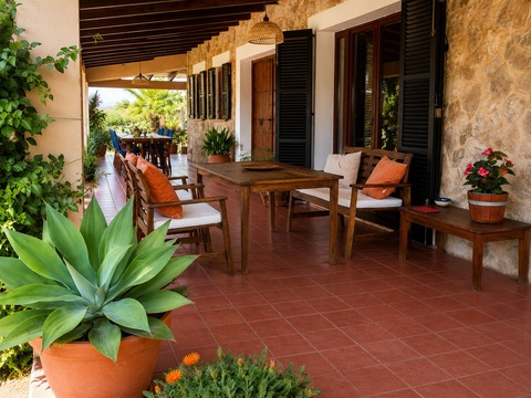 Überdachte Veranda mit massiven Holzbalken und direktem Zugang zu Garten und Essbereich