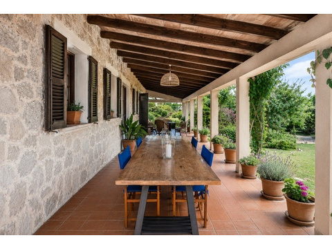 Überdachte Loggia mit massiven Holzbalken und direktem Zugang zum Garten