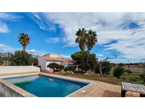 Swimmingpool mit sonniger Freiterrasse und Blick auf die weitläufige Landschaft