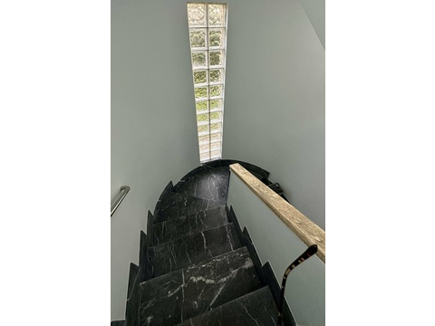 Elegante Treppe mit Marmorstufen und raumhohem Oberlicht