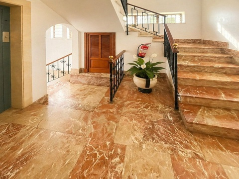 Repräsentatives Treppenhaus mit Marmorboden und eleganten Raumverbindungen zu mehreren Ebenen