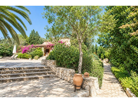 Gepflasterter Zugangsbereich mit Natursteinmauern und mediterraner Gartenarchitektur