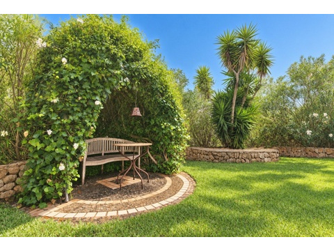 Verwunschener Garten mit angelegten Sitzbereichen und Natursteinmauern