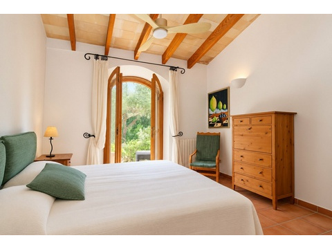 Schlafzimmer mit Holzbalkendecke und direktem Zugang zur Terrasse