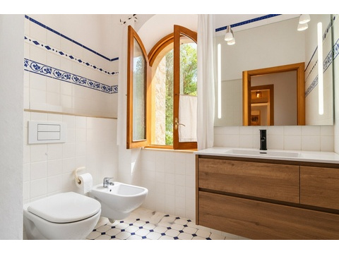 Badezimmer mit Fensterblick, modernem Waschtisch und hochwertiger Ausstattung
