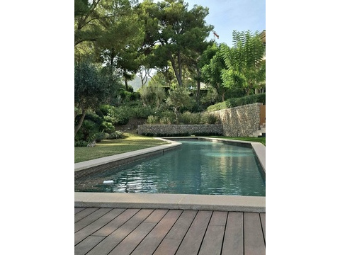 Poolanlage mit harmonischer Gartengestaltung und massiven Natursteinmauern