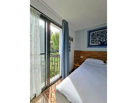 Schlafzimmer mit direktem Balkonzugang und Ausblick ins Grüne