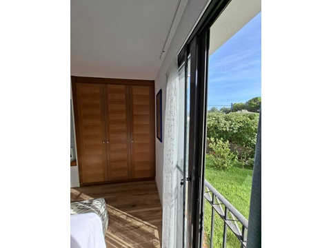 Schlafzimmer mit großflächigen Schiebetüren und freiem Blick auf die Gartenanlage