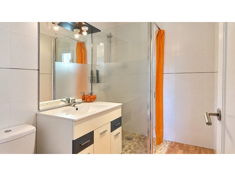 Modernes Badezimmer mit ebenerdiger Dusche und praktischem Waschtischunterschrank