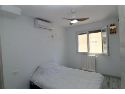 Helles Schlafzimmer mit Klimaanlage, Deckenventilator und Fensterfront zur Straße