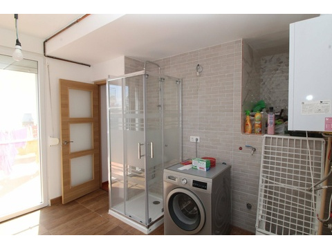 Modernes Badezimmer mit bodengleicher Dusche und praktischer Waschmaschinenintegration