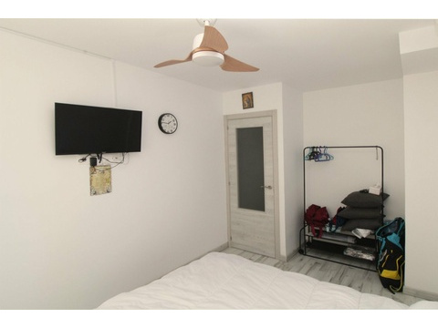 Funktionales Schlafzimmer mit praktischer Raumaufteilung und Deckenventilator