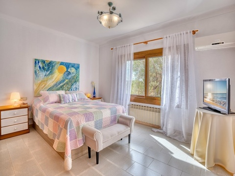 Helles Schlafzimmer mit Klimaanlage, Holzfenstern und optimaler Raumaufteilung