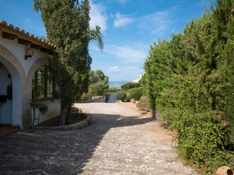 Gepflegter Außenbereich mit mediterraner Architektur und privater Zufahrt