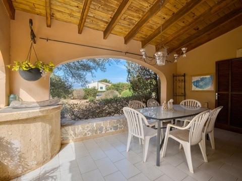 Überdachte Terrasse mit integrierter Außenküche und eleganter Bogenarchitektur