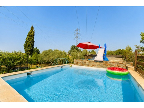Swimmingpool mit integrierter Wasserrutsche und großzügiger Sonnenterrasse