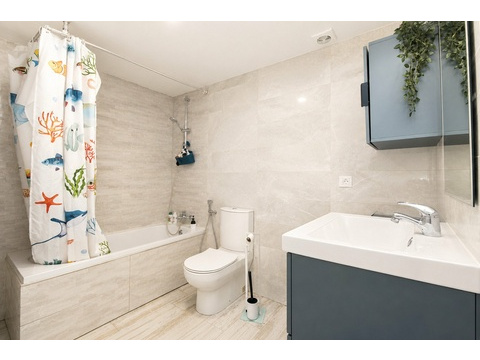 Modernes Badezimmer mit ebenerdiger Dusche, hochwertiger Marmor-Ausstattung und praktischem...