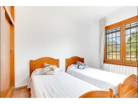 Helles Gästezimmer mit Holzfenstern und optimaler Raumaufteilung