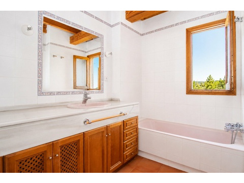 Badezimmer mit breiter Waschtischanlage und Fensterblick ins Grüne
