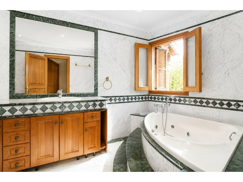 Edles Badezimmer mit Marmor-Ausstattung und freistehender Wanne mit Whirlpool-Funktion