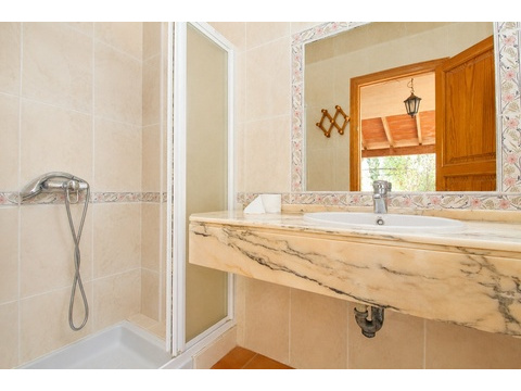 Elegantes Badezimmer mit Marmor-Waschtisch und ebenerdiger Dusche