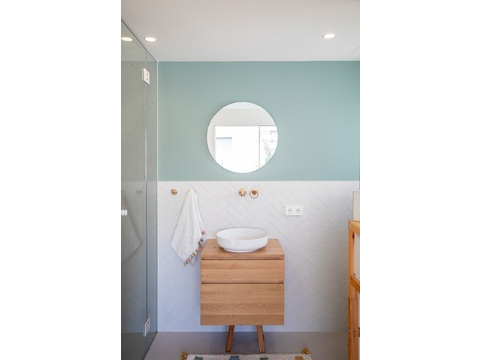 Elegantes Badezimmer mit raumhoher Fliesengestaltung und modernem Waschtischbereich