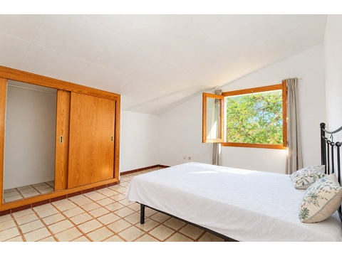 Hauptschlafzimmer mit begehbarem Kleiderschrank und großem Fenster zur Naturaussicht