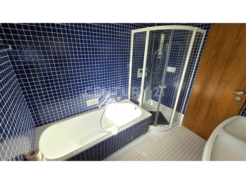 Gegenseite des Badezimmers mit Wanne und Dusche