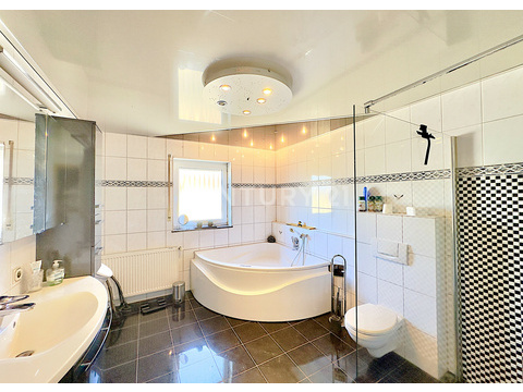 Badezimmer mit Whirlpool-Badewanne und Dusche im Erdgeschoss