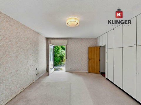 Schlafzimmer mit Einbauschränken und Zugang zum Außenbereich