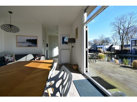 Wohnzimmer mit Terrassentür und Wasserblick – Ferienhaus zu verkaufen Hulshorst (Bad Hoophuizen)