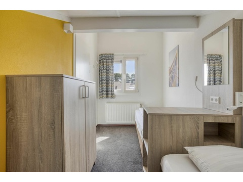 hauptschlafzimmer-kaufen-duinresort-gelbe-wand-doppelbett04