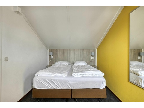 hauptschlafzimmer-kaufen-duinresort-gelbe-wand-doppelbett01