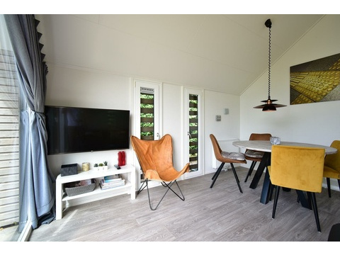 kaufen-freistehendes-ferienhaus-olburgen-wohnzimmer-mit-tv-moebel-und-essbereich-recreatieadviseurs...