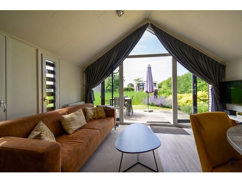 kaufen-freistehendes-ferienhaus-olburgen-wohnzimmer-hohe-decke-und-gartenblick-recreatieadviseurs...