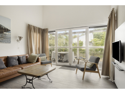 kaufen-freistehendes-ferienhaus-ouddorp-wohnzimmer-schiebetuer-und-terrassenaussicht...