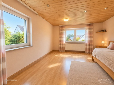 Helles, aufgeräumtes Schlafzimmer mit Holzdecke