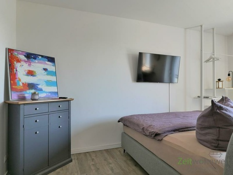 Kommode und Bett hinter dem Raumteiler