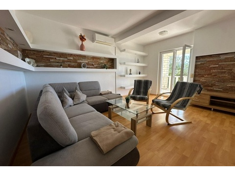 Wohnzimmer mit Sofa, Sessel und modernem Wanddesign