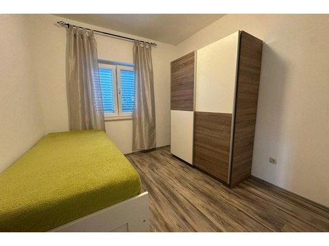 Schlafzimmer mit Einzelbett und Kleiderschrank in heller Ausstattung