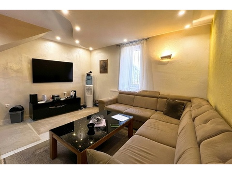 Wohnzimmer mit Ecksofa und Fernseher