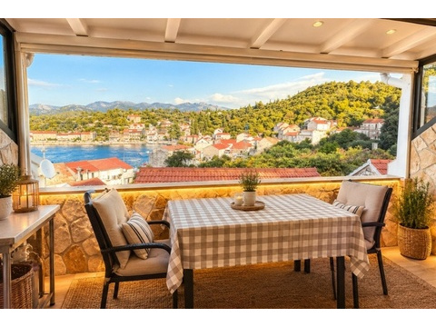 Überdachte Terrasse mit Esstisch und Meerblick