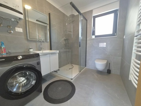 Badezimmer mit Dusche, Toilette und Waschmaschine