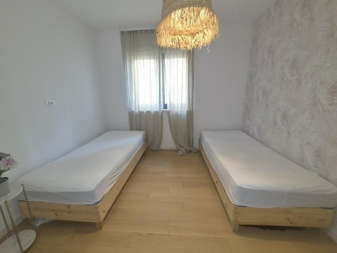 Zweites Schlafzimmer mit Vorhängen am Fenster