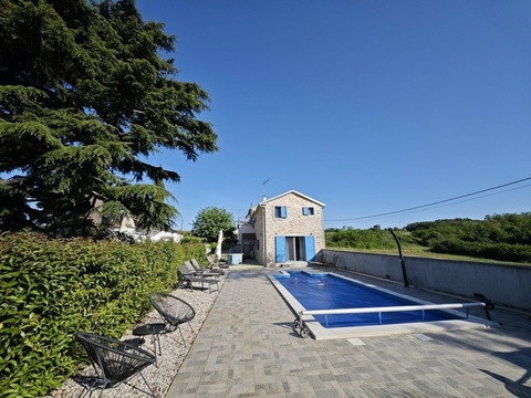 Steinhaus mit Pool und Liegestühlen