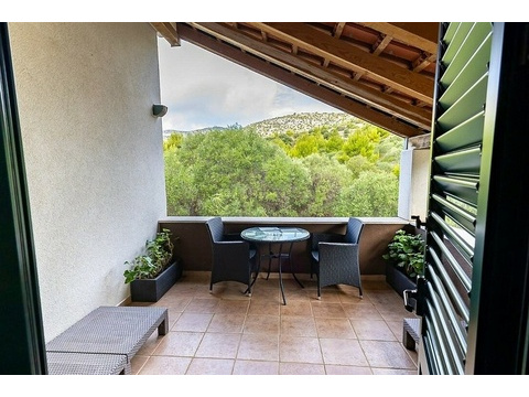 Überdachte Terrasse mit Holzdecke und Gartenmöbeln