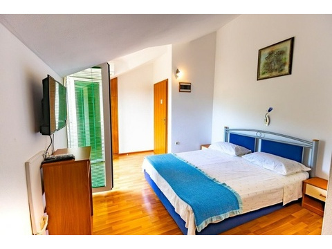Schlafzimmer mit Doppelbett und Fernseher
