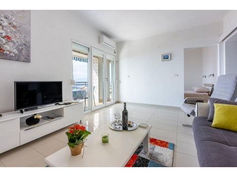 Wohnzimmer mit TV und Zugang zum Balkon mit Meerblick