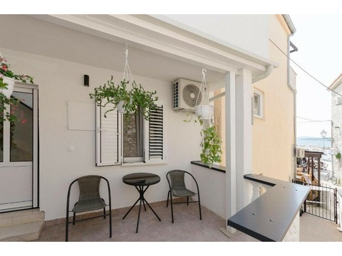 Überdachte Terrasse mit Sitzgelegenheit und Blick zum Meer